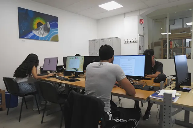 Espace de travail : trois jeunes devant des ordinateurs
