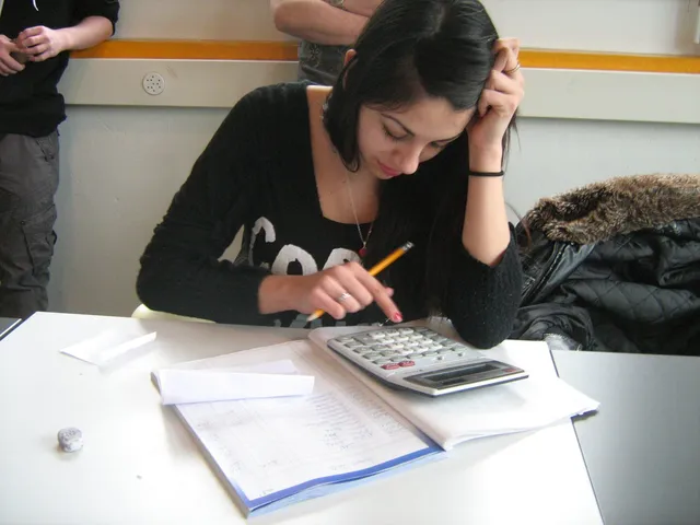 Soutien scolaire : une jeune femme travaille avec une calculatrice